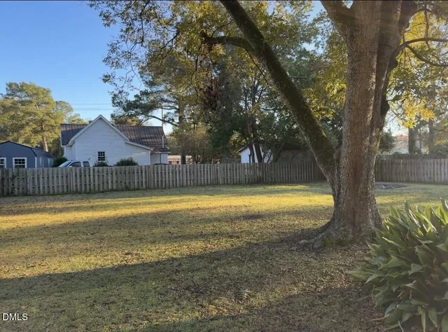 a view of swimming pool with table and wooden fence
