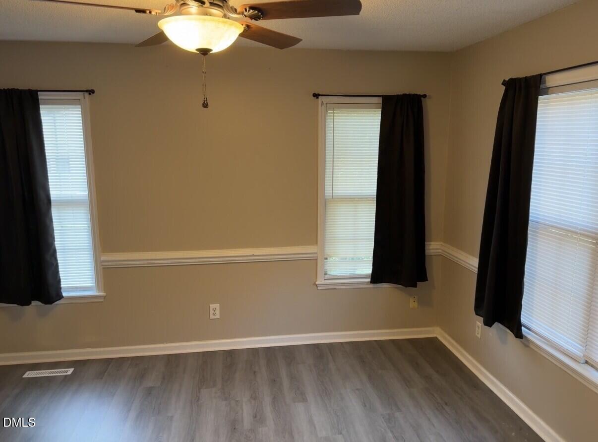 210 South Maple Avenue Kenly, NC 27542 - Photo 6 of 12 an empty room with wooden floor and windows