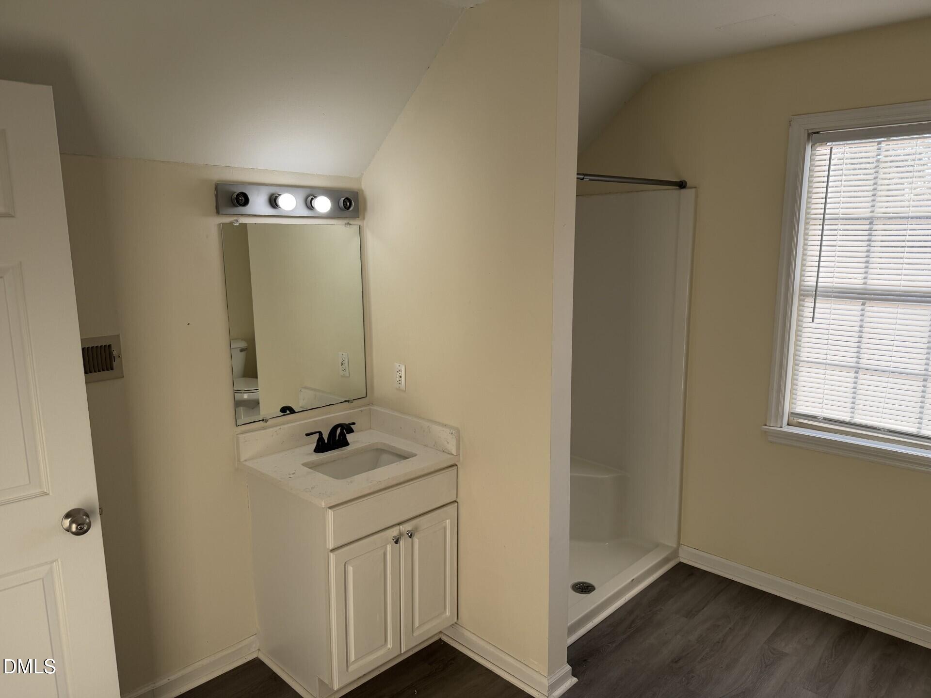 210 South Maple Avenue Kenly, NC 27542 - Photo 9 of 12 a bathroom with a sink a mirror and shower