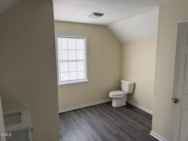 a bathroom with a toilet a sink and a window