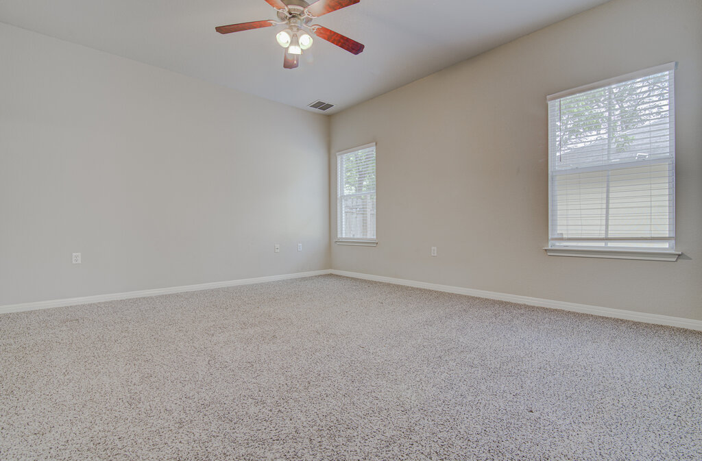 1702 Singleton Avenue, Unit A Austin, TX 78702 - Photo 21 of 27 an empty room with a window and a fan