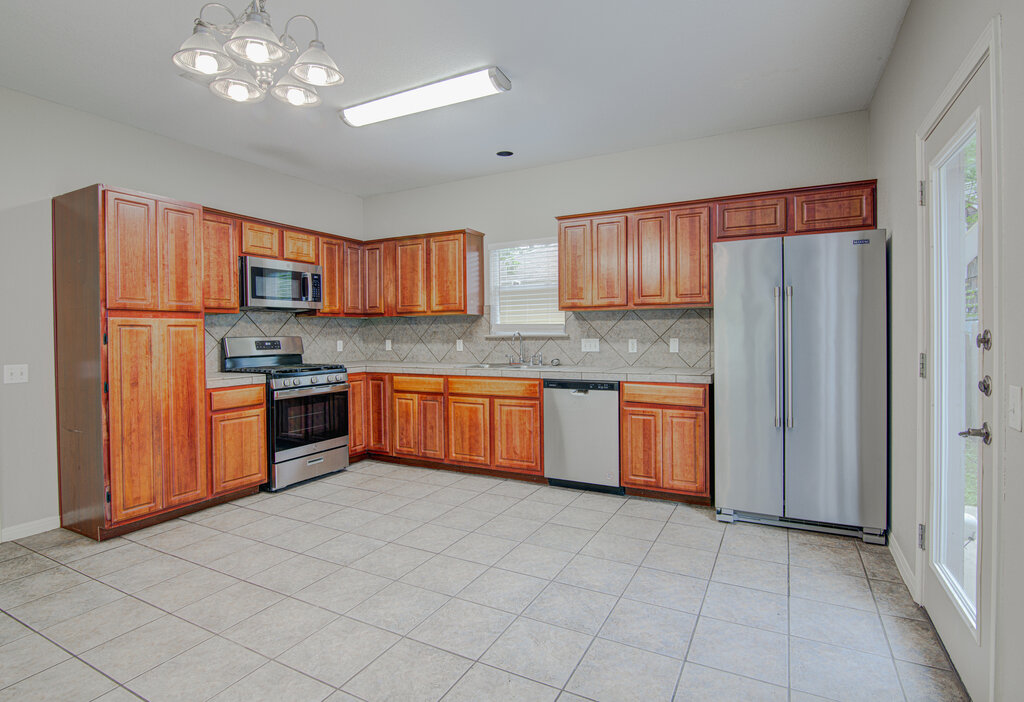 1702 Singleton Avenue, Unit A Austin, TX 78702 - Photo 7 of 27 a kitchen with stainless steel appliances granite countertop a stove sink and refrigerator