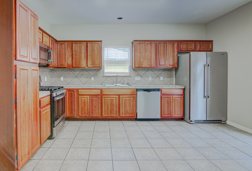 1702 Singleton Avenue, Unit A Austin, TX 78702 - Photo 8 of 27 a kitchen with stainless steel appliances granite countertop a stove a sink dishwasher and a refrigerator