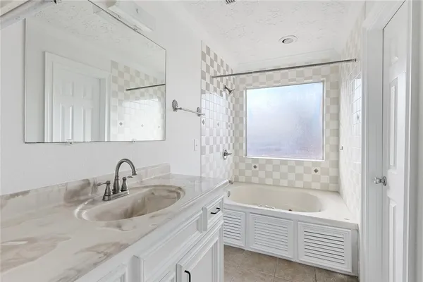 a bathroom with a tub sink and mirror
