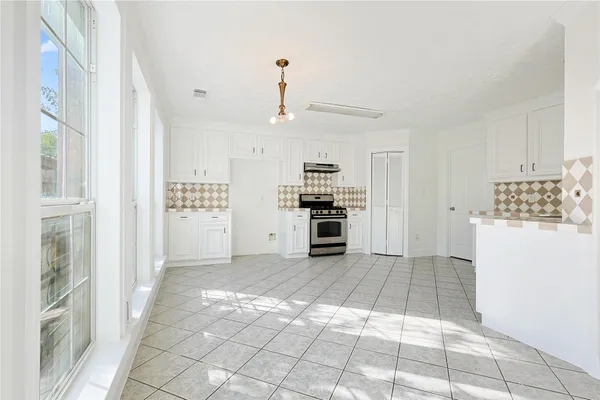 a view of kitchen with granite countertop cabinets and refrigerator