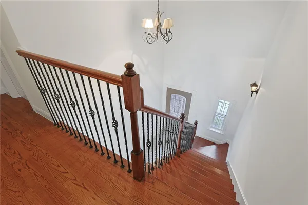 a view of a hallway with wooden floor and staircase