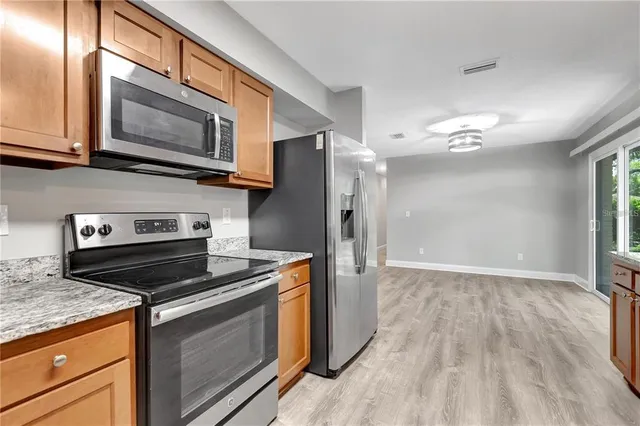 a kitchen with stainless steel appliances granite countertop a stove microwave and refrigerator