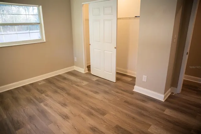 an empty room with wooden floor and a window