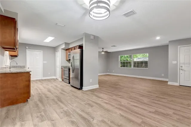 a view of an empty room with a window and wooden floor