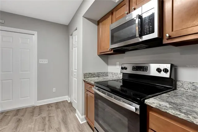 a kitchen with stainless steel appliances granite countertop a stove and a microwave