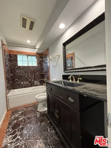 a bathroom with a sink a large mirror and a bathtub