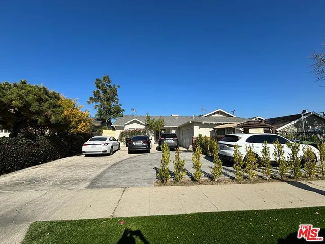 a view of a blue house with yard and car parked