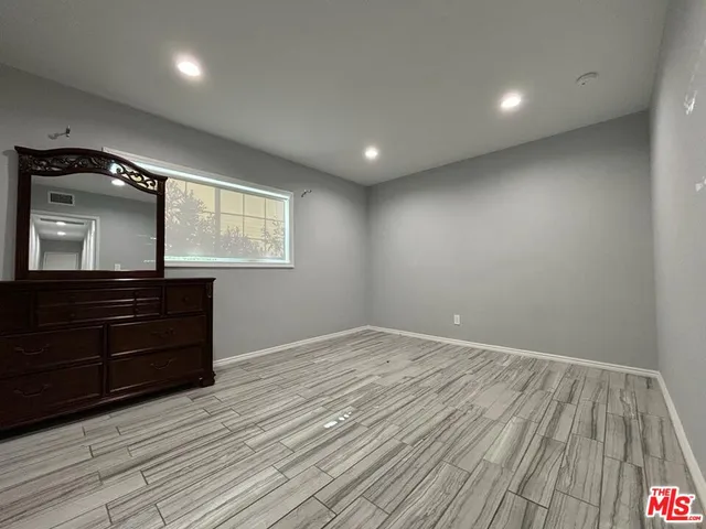an empty room with wooden floor and window