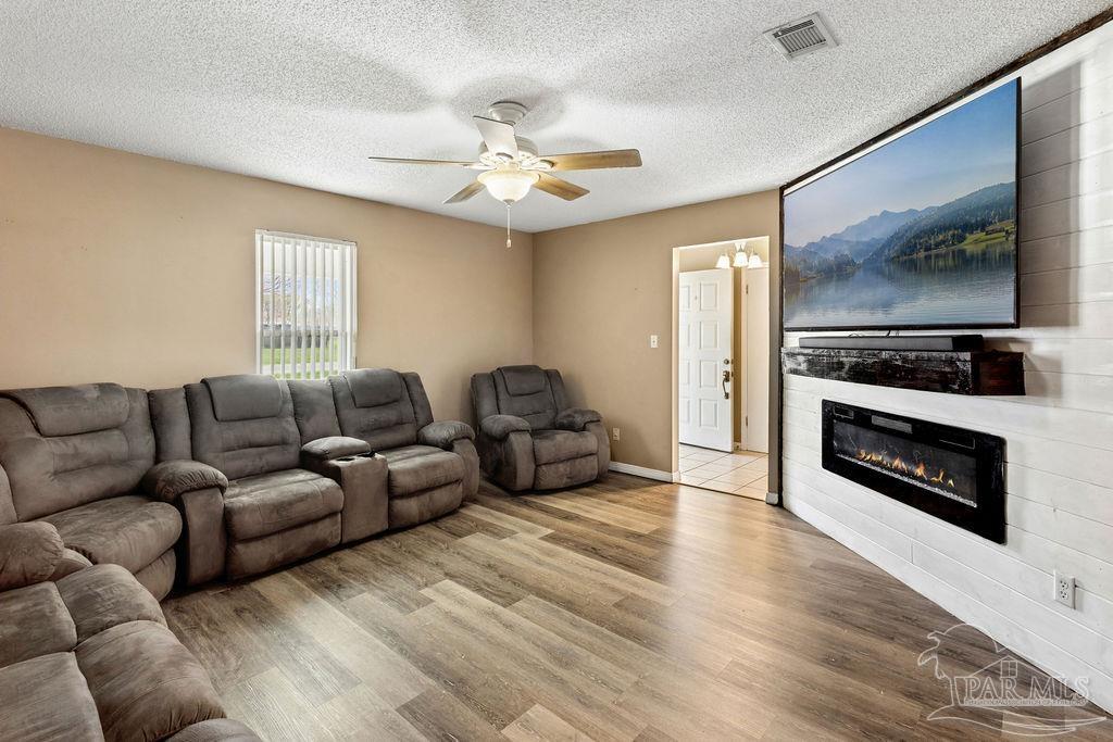 2329 Ryale Road Cantonment, FL 32533 - Photo 3 of 31 a living room with furniture a flat screen tv and a fireplace