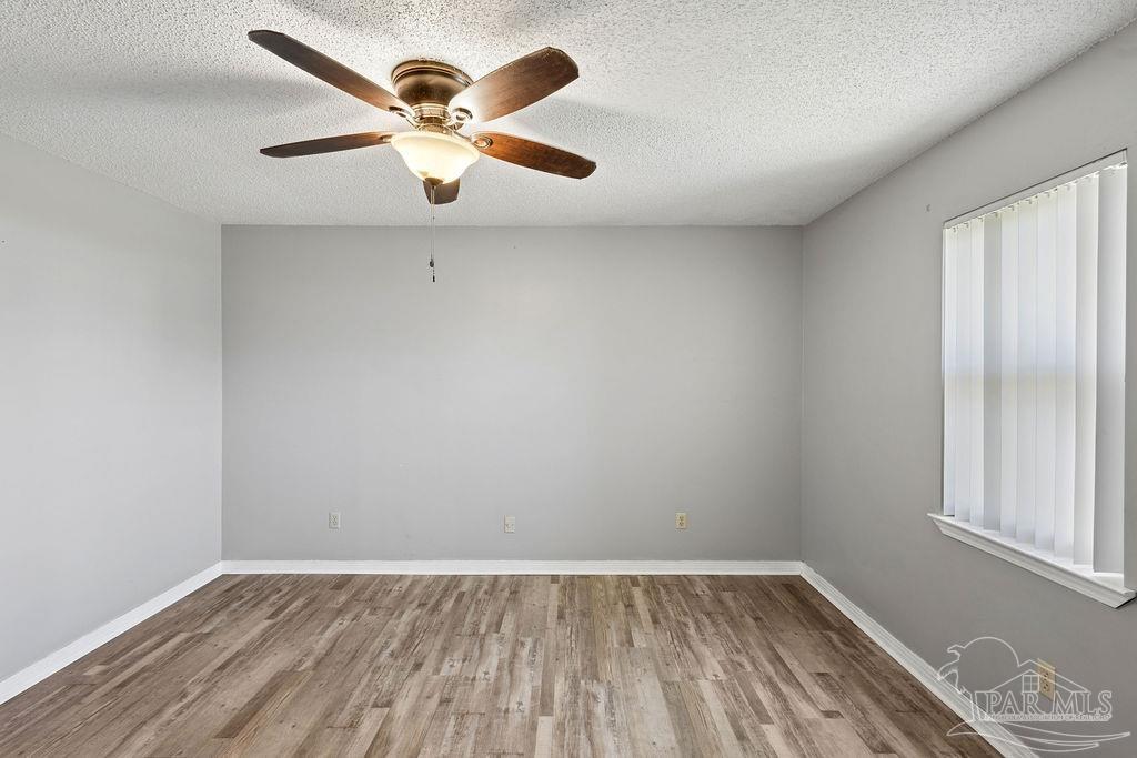 2329 Ryale Road Cantonment, FL 32533 - Photo 10 of 31 an empty room with wooden floor and windows