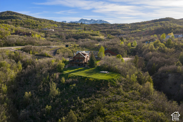 5878 Snowbasin Road Huntsville, UT 84317 - Photo 89 of 90 Wood-sided home with multiple exterior levels, a prominent deck, and a manicured lawn area, situated among varied natural foliage