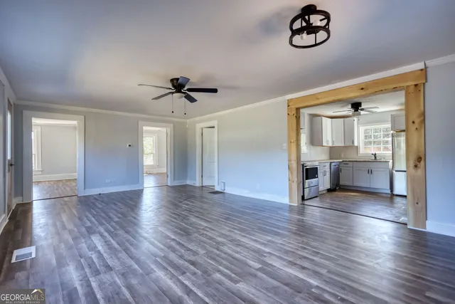 an empty room with wooden floor and windows