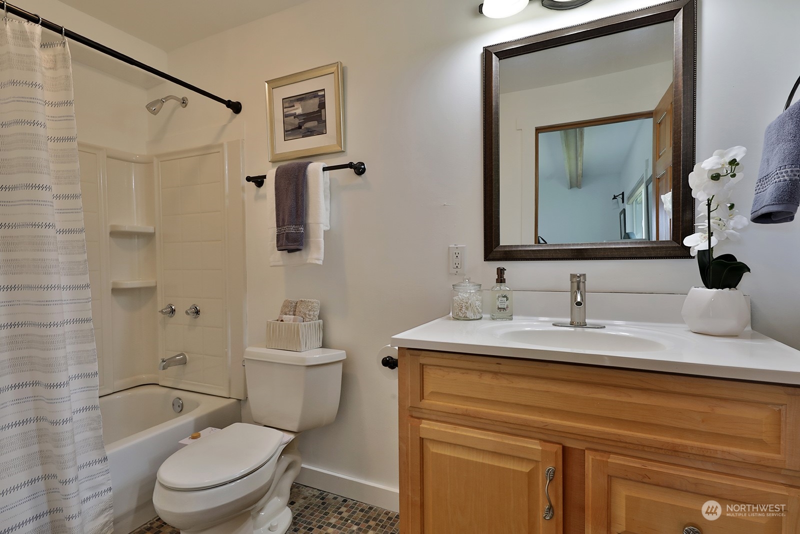 5880 Mutiny Bay Road Freeland, WA 98249 - Photo 25 of 40 a bathroom with a granite countertop sink toilet a mirror and shower