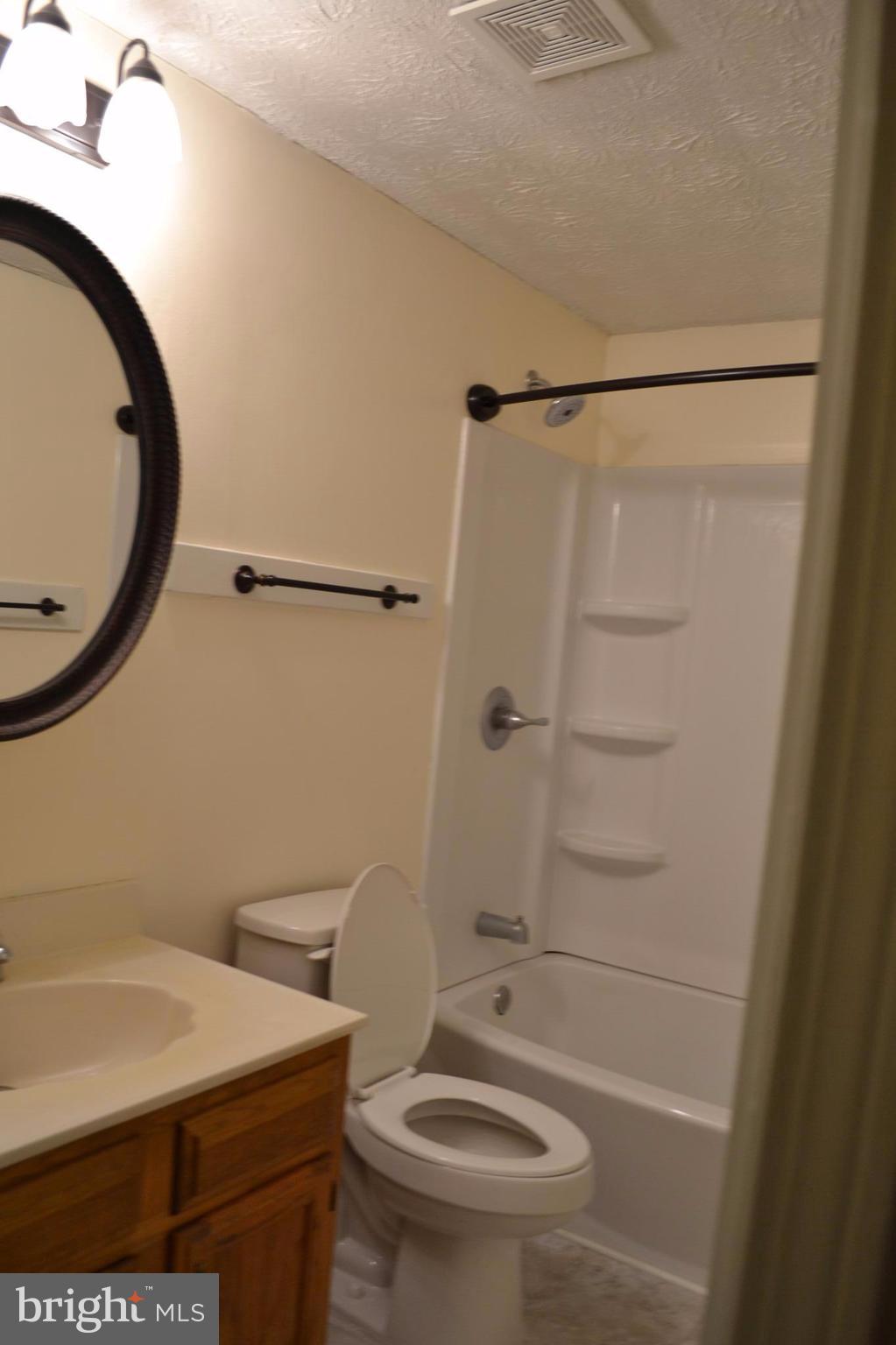 12900 Rousby Hall Road Lusby, MD 20657 - Photo 5 of 8 a bathroom with a sink a toilet and shower