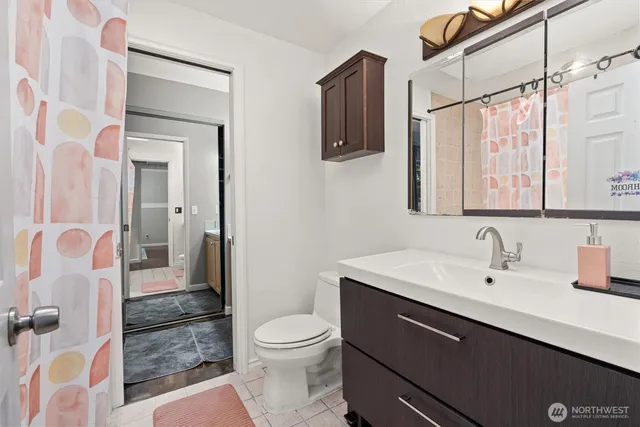 a bathroom with a sink a toilet a mirror and shower