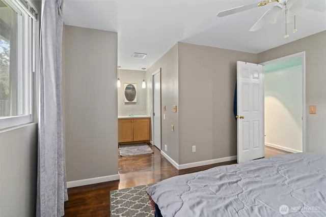 a bedroom with a bed and wooden floor