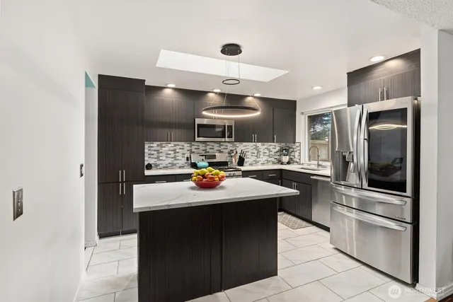 a kitchen with stainless steel appliances a sink stove and refrigerator