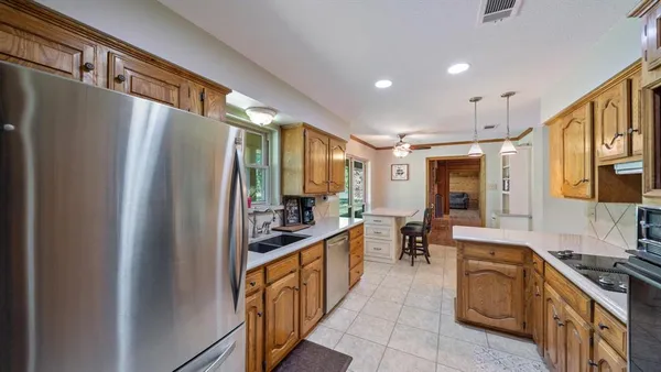 a kitchen with stainless steel appliances granite countertop a refrigerator and a stove