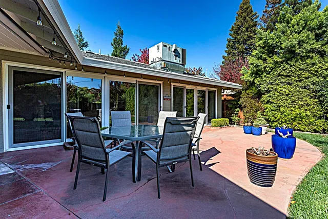 a view of a patio with dining table and chairs and potted plants
