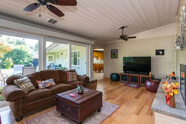 a living room with furniture a flat screen tv and a large window