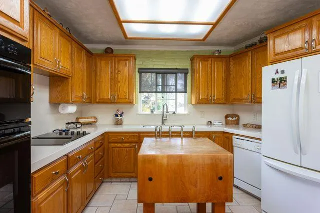 a kitchen with stainless steel appliances granite countertop a sink a stove and a refrigerator
