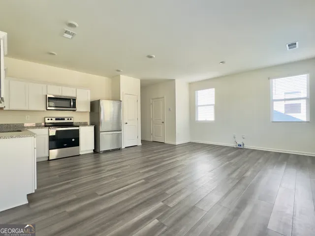 a view of a kitchen with a sink stove and cabinets