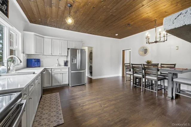 a kitchen with a table chairs a sink dishwasher refrigerator and cabinets