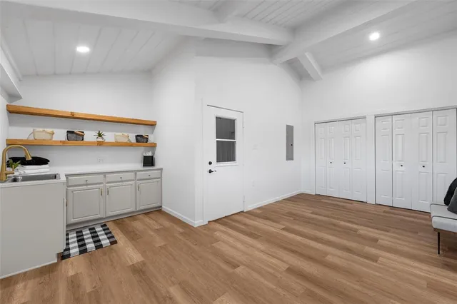 a room with a bed and a view of kitchen