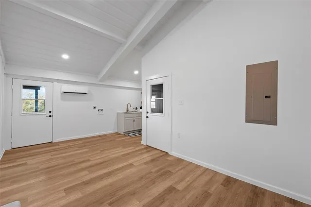 a view of a big room with wooden floor and windows