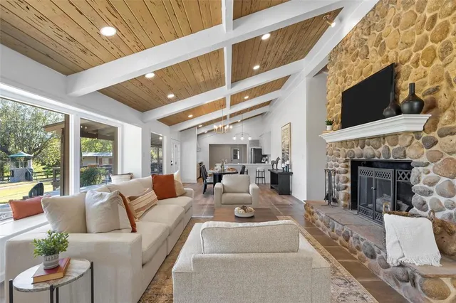 a living room with furniture a fireplace and a flat screen tv