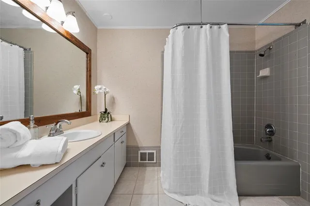 a bathroom with a granite countertop sink and a bathtub