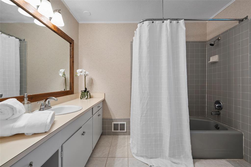 925 Church Road McGregor, TX 76657 - Photo 25 of 40 a bathroom with a granite countertop sink and a bathtub