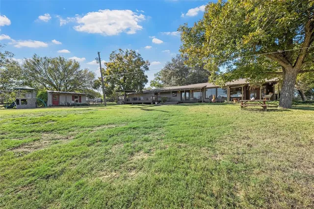 a view of a house with a yard and sitting area