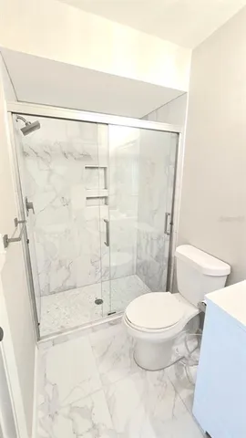 a bathroom with a toilet and a shower