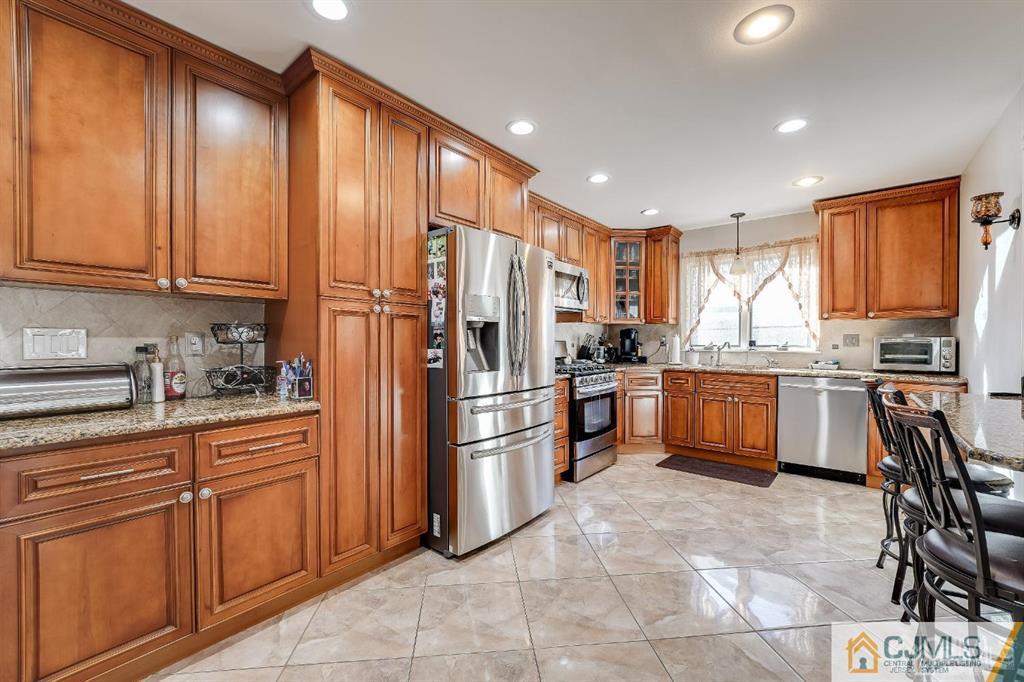 5 Starkin Road East Brunswick, NJ 08850 - Photo 6 of 34 a kitchen with stainless steel appliances granite countertop a refrigerator sink and cabinets