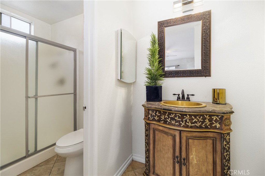 6897 Crest Avenue Riverside, CA 92503 - Photo 18 of 26 a bathroom with a granite countertop toilet sink and mirror