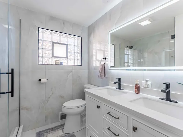 a bathroom with a sink a toilet and shower