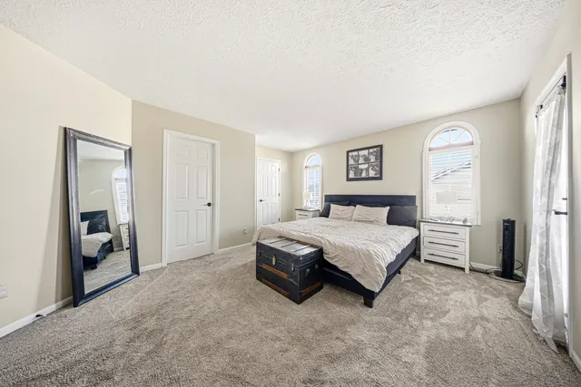 a spacious bedroom with a bed and a cabinets