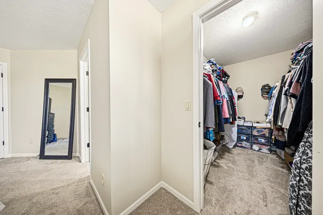 a view of walk in closet with clothes and shoes
