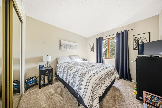 a bedroom with a bed and a flat tv screen on dresser