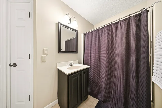 a bathroom with a sink a mirror and a shower curtain
