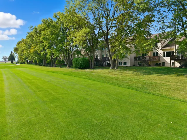a backyard of a house with lots of green space and fountain