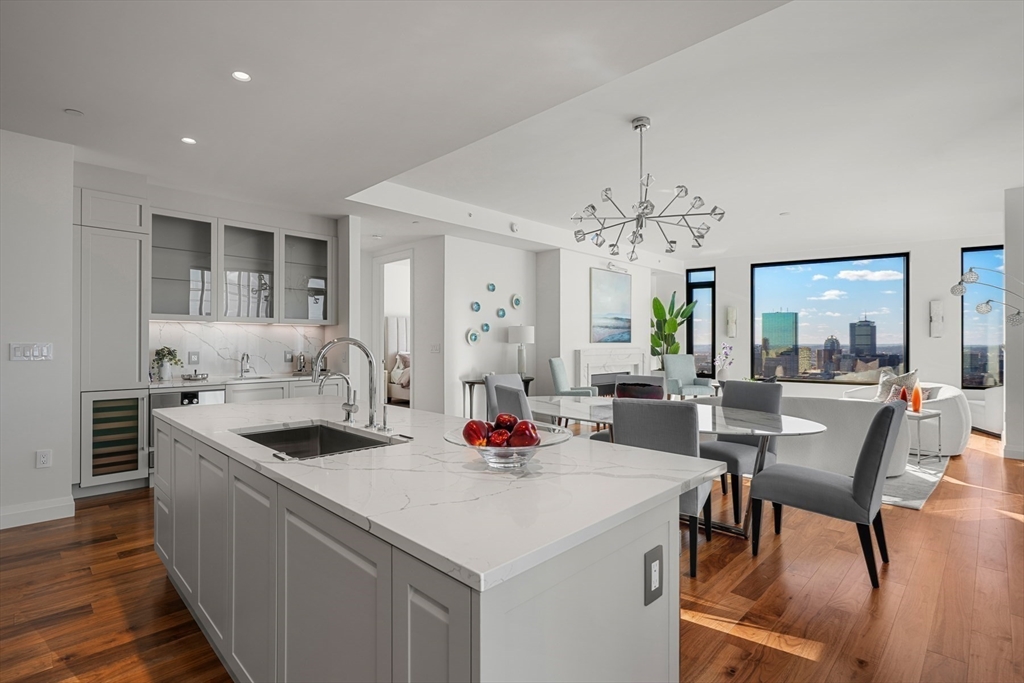 110 Sudbury Street, Unit 3601 Boston, MA 02114 - Photo 7 of 42 a kitchen with stainless steel appliances kitchen island granite countertop a table and chairs in it