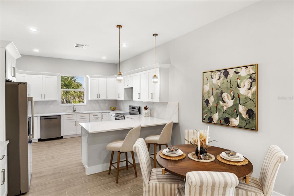 38 Lark Drive Placida, FL 33946 - Photo 13 of 46 a kitchen with stainless steel appliances kitchen island granite countertop a dining table chairs and a refrigerator