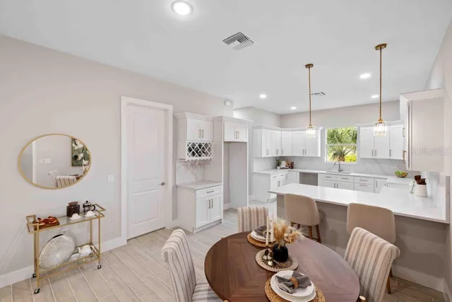 a dining room with furniture a kitchen view and a chandelier